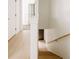 Hallway with light wood floors, neutral walls, and a staircase leading to another level at 1601 Park Ave # 214, Denver, CO 80218