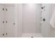 Modern shower featuring white tiles, glass door, and matte black fixtures and shelves at 1601 Park Ave # 214, Denver, CO 80218