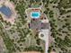 Stunning aerial view showcases the expansive property with a pool, fire pit, and circular driveway at 1505 Castlecombe Ln, Monument, CO 80132