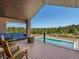 Spacious back porch with comfortable seating, a barrel table, and a stunning view of the yard and pool at 1505 Castlecombe Ln, Monument, CO 80132