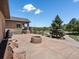 Spacious backyard with a stone fire pit, lush landscaping, and views of the surrounding greenery at 1505 Castlecombe Ln, Monument, CO 80132