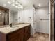 Bathroom featuring a granite-topped vanity, decorative mirror, and tiled shower with glass door at 1505 Castlecombe Ln, Monument, CO 80132