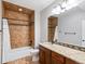 Bathroom features tile walls, a bathtub, wood vanity with granite countertop at 1505 Castlecombe Ln, Monument, CO 80132