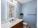 Bright bathroom featuring modern vanity, a lighted mirror and a shower with marble tile at 1505 Castlecombe Ln, Monument, CO 80132