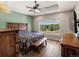 Bedroom with wood floors, a large window overlooking a treed backyard, and wooden furniture at 1505 Castlecombe Ln, Monument, CO 80132