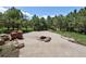 Relaxing fire pit area with stone accents and surrounding trees for a peaceful outdoor gathering space at 1505 Castlecombe Ln, Monument, CO 80132