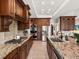 Well-equipped kitchen with granite countertops, stainless steel appliances, and custom cabinetry at 1505 Castlecombe Ln, Monument, CO 80132