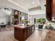 Open-concept kitchen features a large island with sink, a stone fireplace, and seamless access to the living room at 1505 Castlecombe Ln, Monument, CO 80132