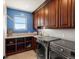 Well-equipped laundry room with modern appliances, storage, and stylish finishes at 1505 Castlecombe Ln, Monument, CO 80132