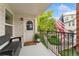 Charming covered balcony includes an American flag, bench seating, potted plant and a view of green space at 1670 S Deframe St # B2, Lakewood, CO 80228