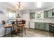 Bright kitchen featuring stainless appliances, green cabinets, barstool seating, and luxury vinyl plank flooring at 1670 S Deframe St # B2, Lakewood, CO 80228