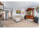 Open concept living room flows into the kitchen, featuring a neutral sofa, stainless steel fridge, and a display cabinet at 1670 S Deframe St # B2, Lakewood, CO 80228