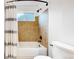 Cozy bathroom featuring a shower and tub combination with a tiled wall and modern shower curtain at 12201 N Holly Way, Brighton, CO 80602
