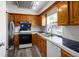 Well-lit kitchen with stainless steel refrigerator, dark countertops and wood cabinets at 2082 S Helena St # C, Aurora, CO 80013