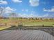 Backyard view from the wood deck; open grass and trees in the distance at 9515 Bexley Dr, Highlands Ranch, CO 80126