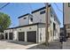 Modern homes with garages in a contemporary style, featuring black trim, white siding and black garage doors at 1563 N Hooker St, Denver, CO 80204
