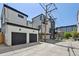 Modern homes with garages in a contemporary style, featuring black trim, white siding and black garage doors at 1563 N Hooker St, Denver, CO 80204