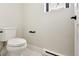 Modern half bath featuring a toilet, a window, and modern fixtures at 1563 N Hooker St, Denver, CO 80204