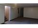 Large unfinished basement with carpeting provides an open space, with white walls and a stairway at 1255 Yates St, Denver, CO 80204