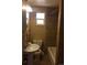 Narrow bathroom features a pedestal sink, toilet, and tub with tile surround and an overhead light at 1255 Yates St, Denver, CO 80204