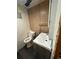 View of a compact bathroom with vinyl flooring, a vanity, and a toilet, featuring paneled walls at 1255 Yates St, Denver, CO 80204