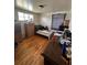 Small bedroom with hardwood floors and a window, featuring a simple bed and functional furniture at 1255 Yates St, Denver, CO 80204