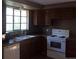 Functional kitchen featuring wood cabinets, an electric range, and essential appliances, bathed in natural light at 1255 Yates St, Denver, CO 80204