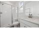 Clean bathroom featuring a walk-in shower with glass door, white tile, and modern fixtures at 8630 Pennycress Dr, Littleton, CO 80125