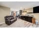 Finished basement with dark cabinets, a sink, and a comfortable leather couch at 2835 S Jebel Way, Aurora, CO 80013