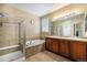 Bright bathroom with a bathtub, a walk-in shower and double sink vanity with wooden cabinets at 2835 S Jebel Way, Aurora, CO 80013