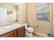 Well-lit half-bath with wood style floors, a toilet, and a sink with wood cabinets at 2835 S Jebel Way, Aurora, CO 80013