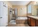 Beautiful bathroom featuring a walk-in shower, a tub and a vanity with wooden cabinets at 2835 S Jebel Way, Aurora, CO 80013