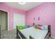 Bedroom with pink walls, unicorn decals, and a bed with stuffed animals at 2835 S Jebel Way, Aurora, CO 80013
