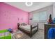 Bedroom with pink walls, unicorn decals, a bed with stuffed animals, and a rainbow rug at 2835 S Jebel Way, Aurora, CO 80013