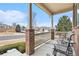 Inviting front porch featuring brick columns, railing and comfortable seating area at 2835 S Jebel Way, Aurora, CO 80013