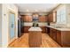Well-lit kitchen with dark cabinetry, island with tile countertop, and stainless steel refrigerator at 2835 S Jebel Way, Aurora, CO 80013