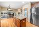 Open kitchen features dark cabinets, an island with tile countertop, and stainless steel refrigerator at 2835 S Jebel Way, Aurora, CO 80013
