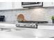 Close-up of modern gas cooktop and stylish backsplash at 1245 N Utica St # 103, Denver, CO 80204