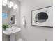 Small half bathroom with pedestal sink and floating vanity at 1245 N Utica St # 103, Denver, CO 80204