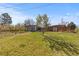 Wide backyard with green lawn, young trees, a modern shed and a wood fence at 3035 E Maplewood Ave, Centennial, CO 80121