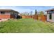 Beautiful backyard featuring a green lawn, a wood fence, trees and an outdoor shed at 3035 E Maplewood Ave, Centennial, CO 80121