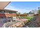 Backyard patio featuring an outdoor dining table, chairs, a green lawn, and garden at 3035 E Maplewood Ave, Centennial, CO 80121