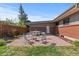 Backyard patio featuring an outdoor seating area with a fire pit, lush lawn, and garden at 3035 E Maplewood Ave, Centennial, CO 80121