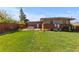 Spacious backyard with green lawn, patio seating area, modern fence, and brick accents at 3035 E Maplewood Ave, Centennial, CO 80121