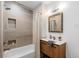 Modern bathroom featuring stylish tile, a soaking tub, and a wood vanity, creating a relaxing and spa-like atmosphere at 3035 E Maplewood Ave, Centennial, CO 80121