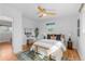 Bright bedroom features a modern ceiling fan, a wooden bench, and beautiful hardwood floors at 3035 E Maplewood Ave, Centennial, CO 80121