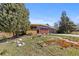 Inviting home exterior featuring a blend of wood, brick, a landscaped front yard, and a convenient two-car garage at 3035 E Maplewood Ave, Centennial, CO 80121