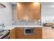 Kitchen with modern wooden cabinetry, stainless steel microwave, and view into living area at 3035 E Maplewood Ave, Centennial, CO 80121