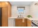 Kitchen features stainless steel appliances, wooden cabinets, white countertops and backsplash, and a window at 3035 E Maplewood Ave, Centennial, CO 80121