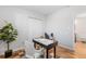 Well-lit office space with wood floors, a built-in closet, a desk, and bright white walls at 3035 E Maplewood Ave, Centennial, CO 80121